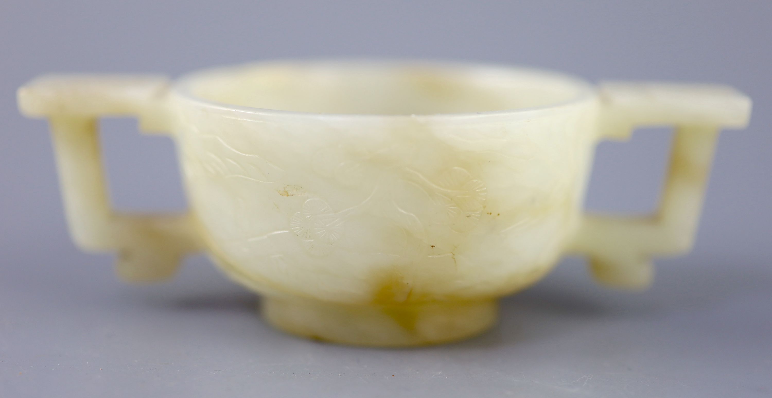 A Chinese pale celadon and russet jade cup, 17th/18th century, 12.5cm wide
